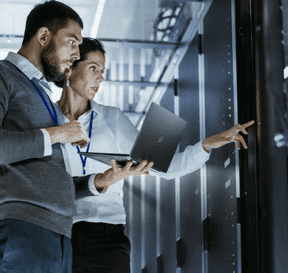 Muž a žena pri serveri sa dívajú do notebooku