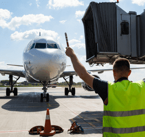 Operátor na letisku dáva signál lietadlu k pristávaniu