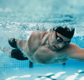 Plavec pri kraule pod vodou v bazéne