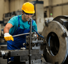 Strojník pracuje pri výrobnej strojárenskej linke