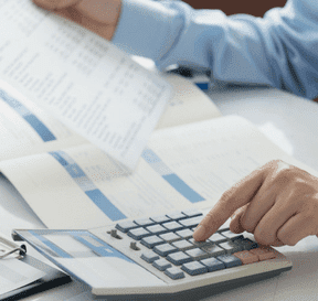 Človek počíta na kalkulačke a díva sa do zmluvy